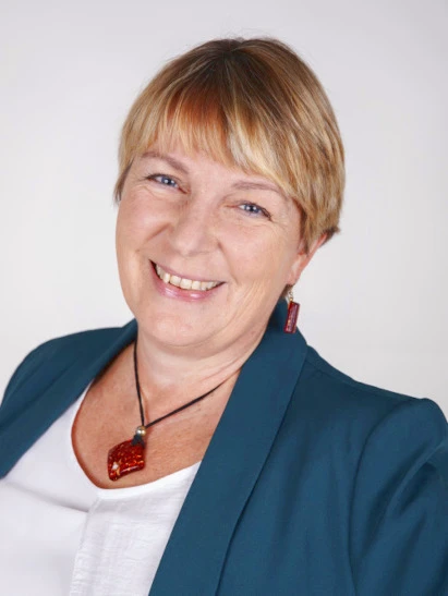 Portrait einer professionellen lächelnden blonden Frau in einem dunkelblauen Blazer