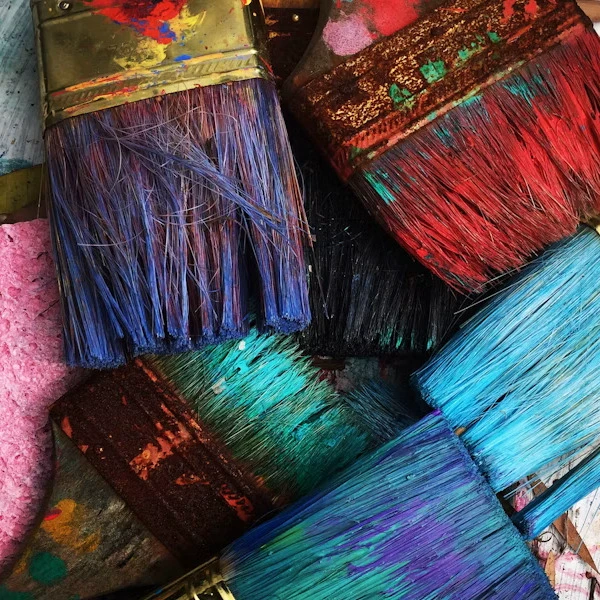 Bunte gefärbte Pinsel in verschiedenen Farben und Größen auf einem Stapel